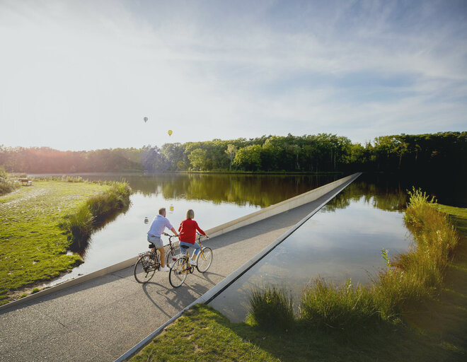 Koppel fietst door het water in Bokrijk Genk