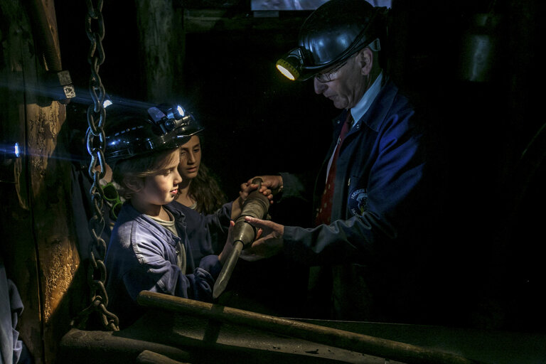 ex-mijnwerker doet rondleiding voor kinderen in mijnmuseum beringen