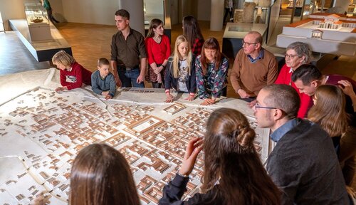 Bezoekers rond een maquette van de eerste stad van België in het Gallo-Romeins Museum